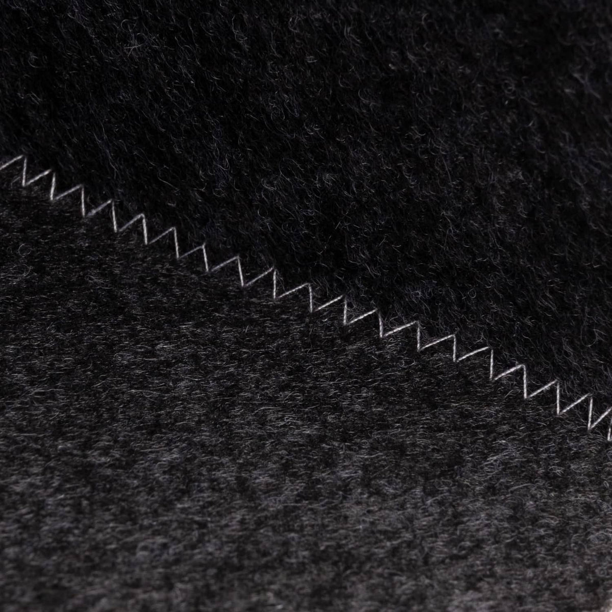 Dark grey wool sauna hat, fabric texture with white zigzag trim along edge