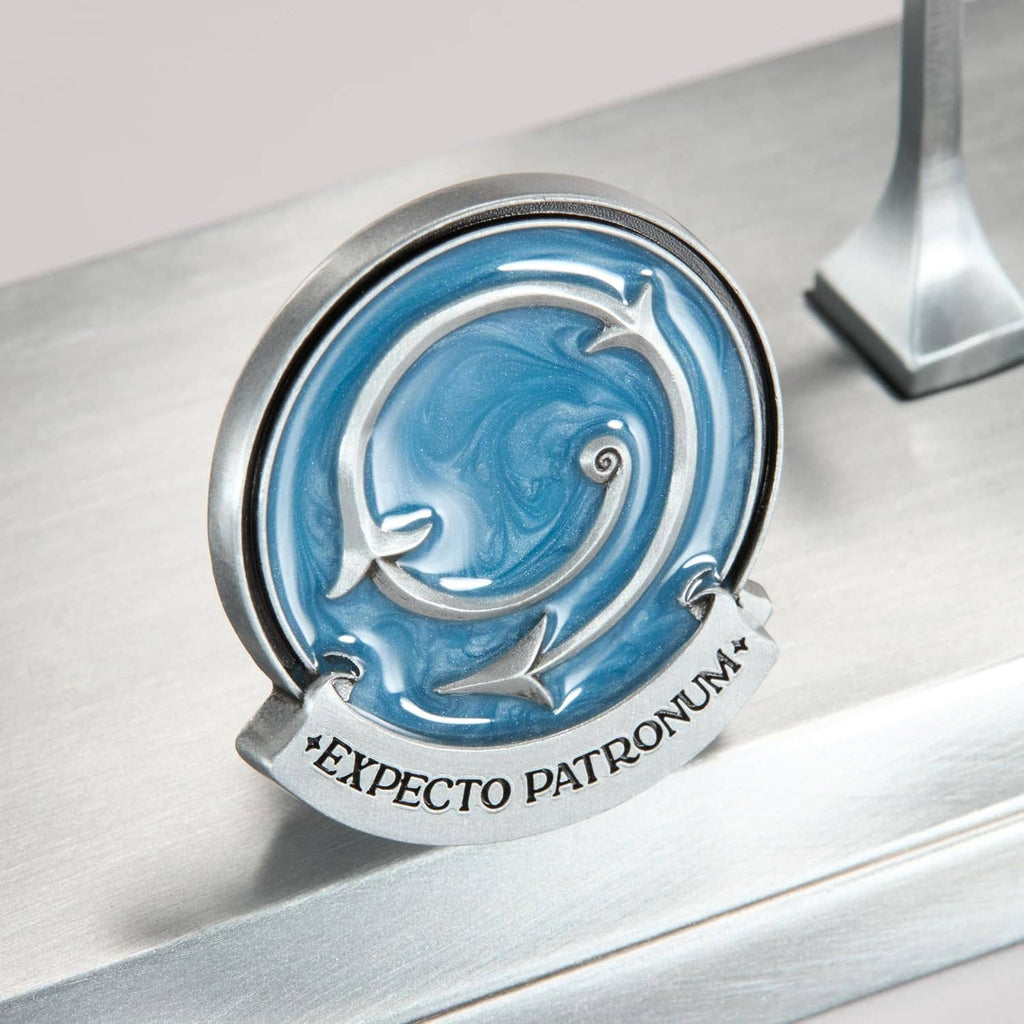 Silver stand medallion with blue emblem and ribbon text: EXPECTO PATRONUM