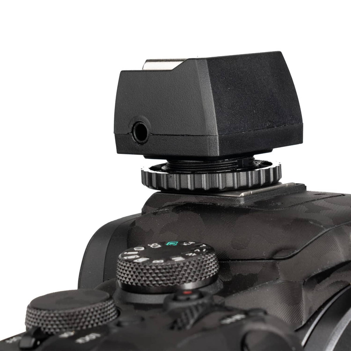 Mounted hot shoe adapter showing side round sync jack and serrated dial
