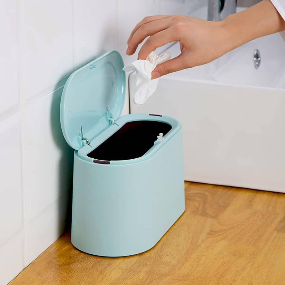 Light blue mini trash can with lid open, inner bin visible and ready to empty