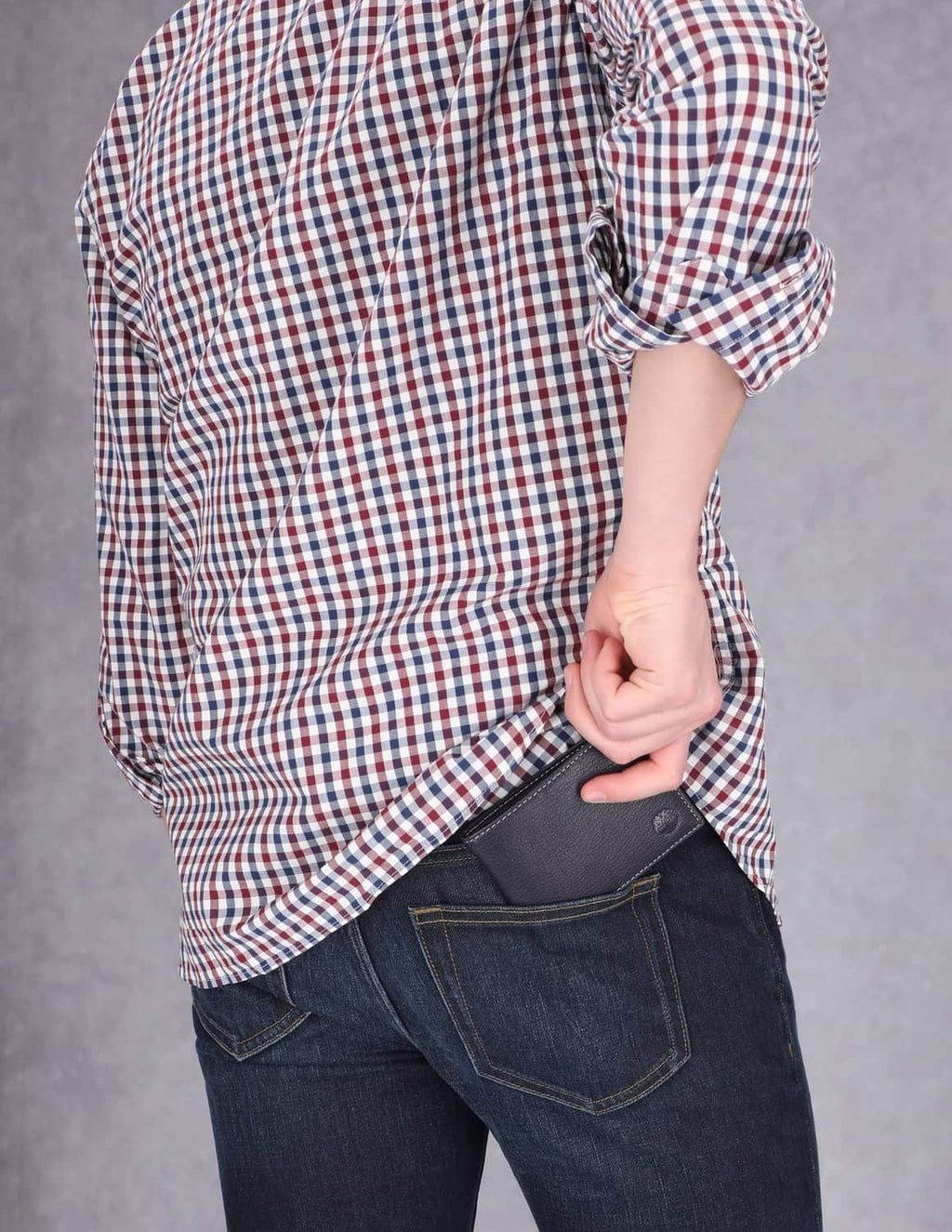 Navy leather bifold wallet tucked into back jeans pocket.
