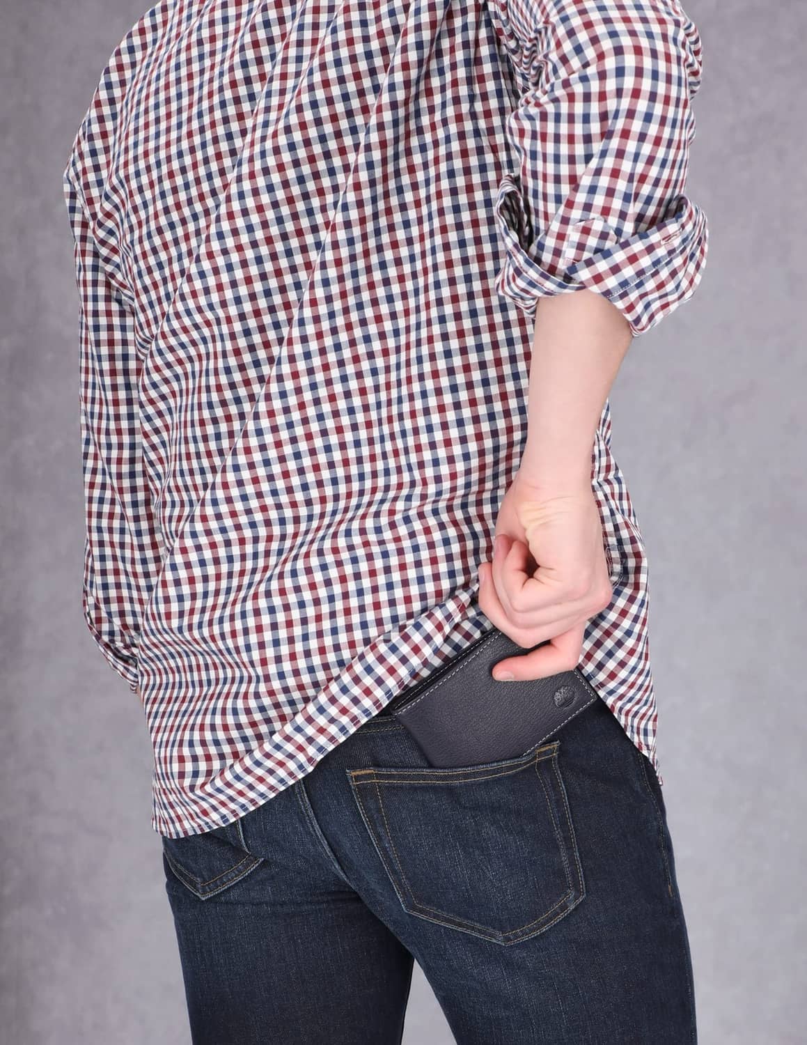 Navy leather bifold wallet tucked into back jeans pocket.