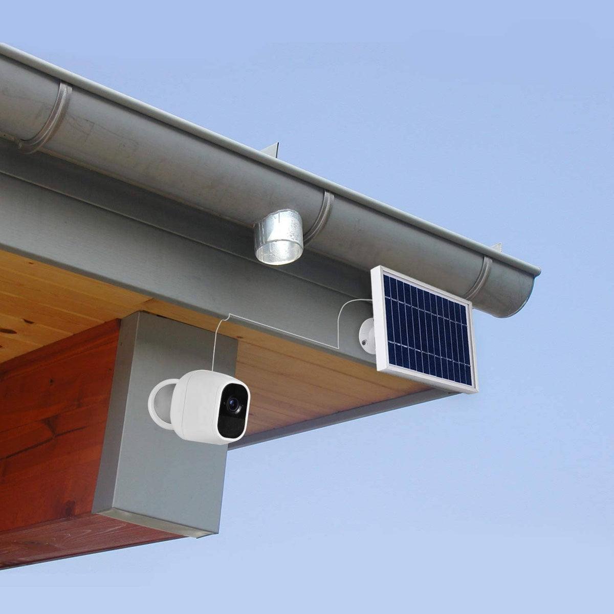 Outdoor security camera with white mount and small solar panel on a building edge