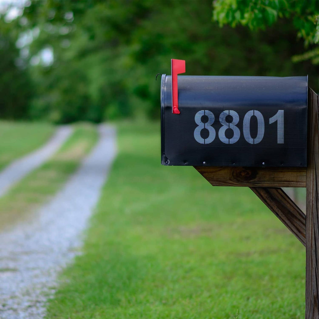 Mailbox address stencil number 8801 on a dark sign