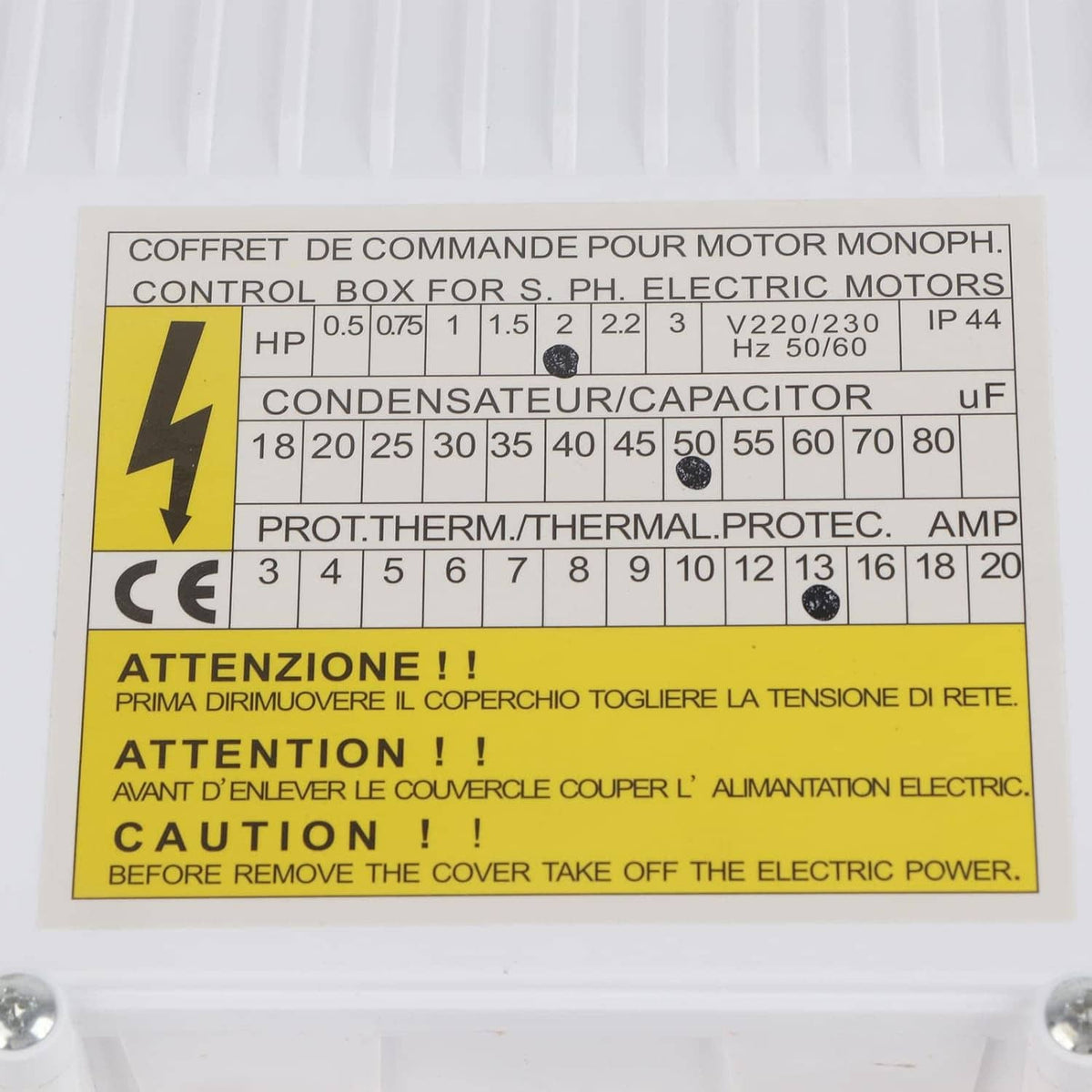 Close-up label on white submersible pump controller with yellow warning panel text.