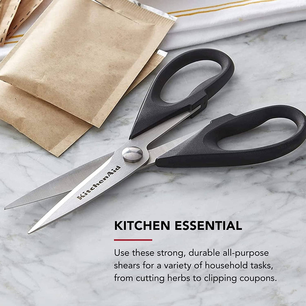 Kitchen shears with stainless blades and black loop handles on a marble surface