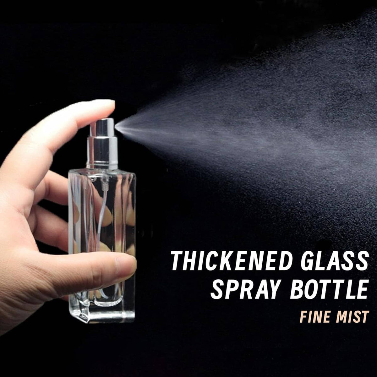 Hand holding clear thick glass perfume spray bottle producing fine mist