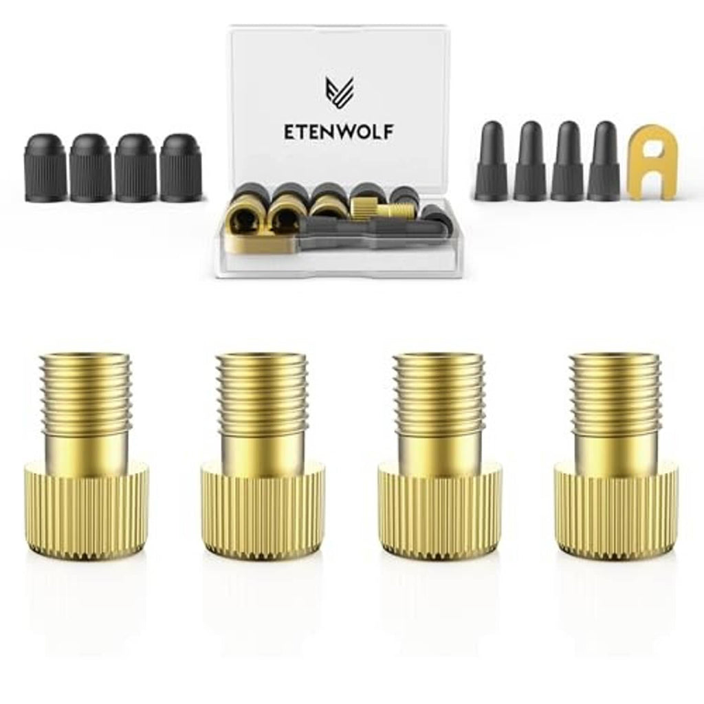 Four brass threaded Presta-to-Schrader valve adapters with black caps, on white background.