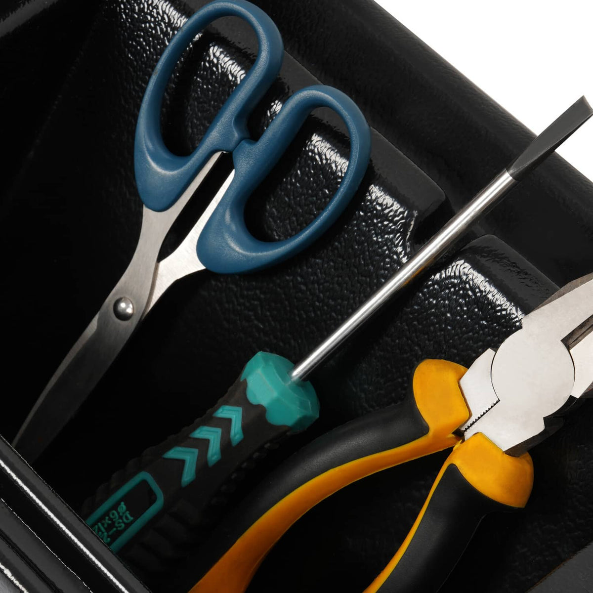 Close-up of black cab caddie slots holding tools and a screwdriver in organizer tray.