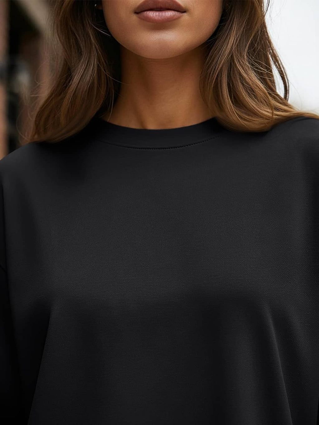 Women’s black long sleeve T-shirt close-up of crew neck and smooth fabric