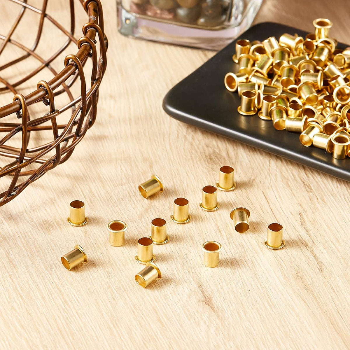 Brass shelf pin sleeves, scattered short cylinders on a light wood surface
