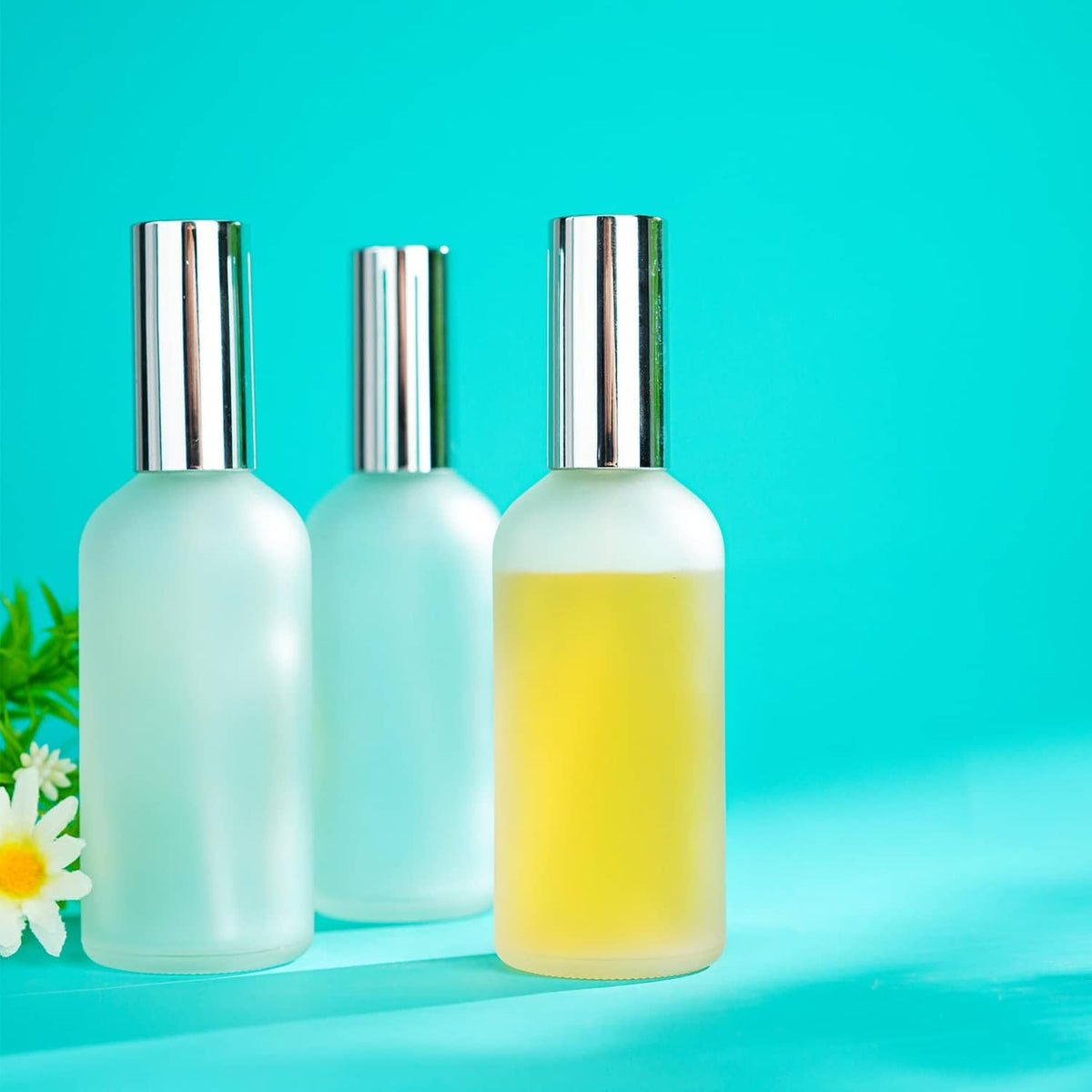 3-pack frosted glass perfume atomizer bottles with chrome caps, one with yellow liquid