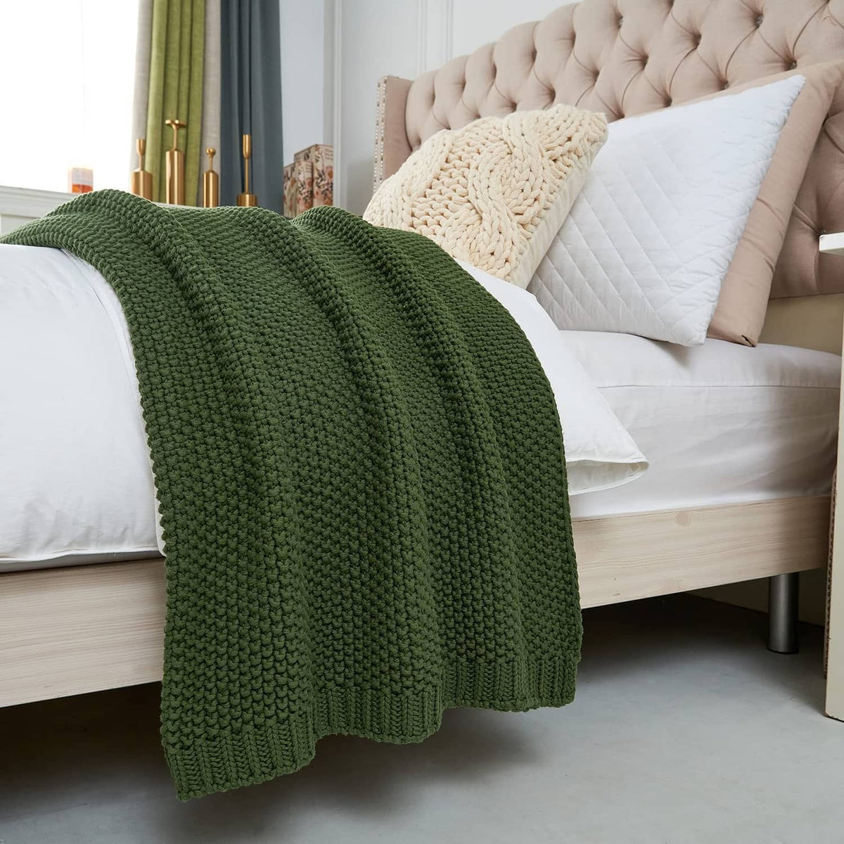 Olive green chunky cable knit throw blanket over a couch arm