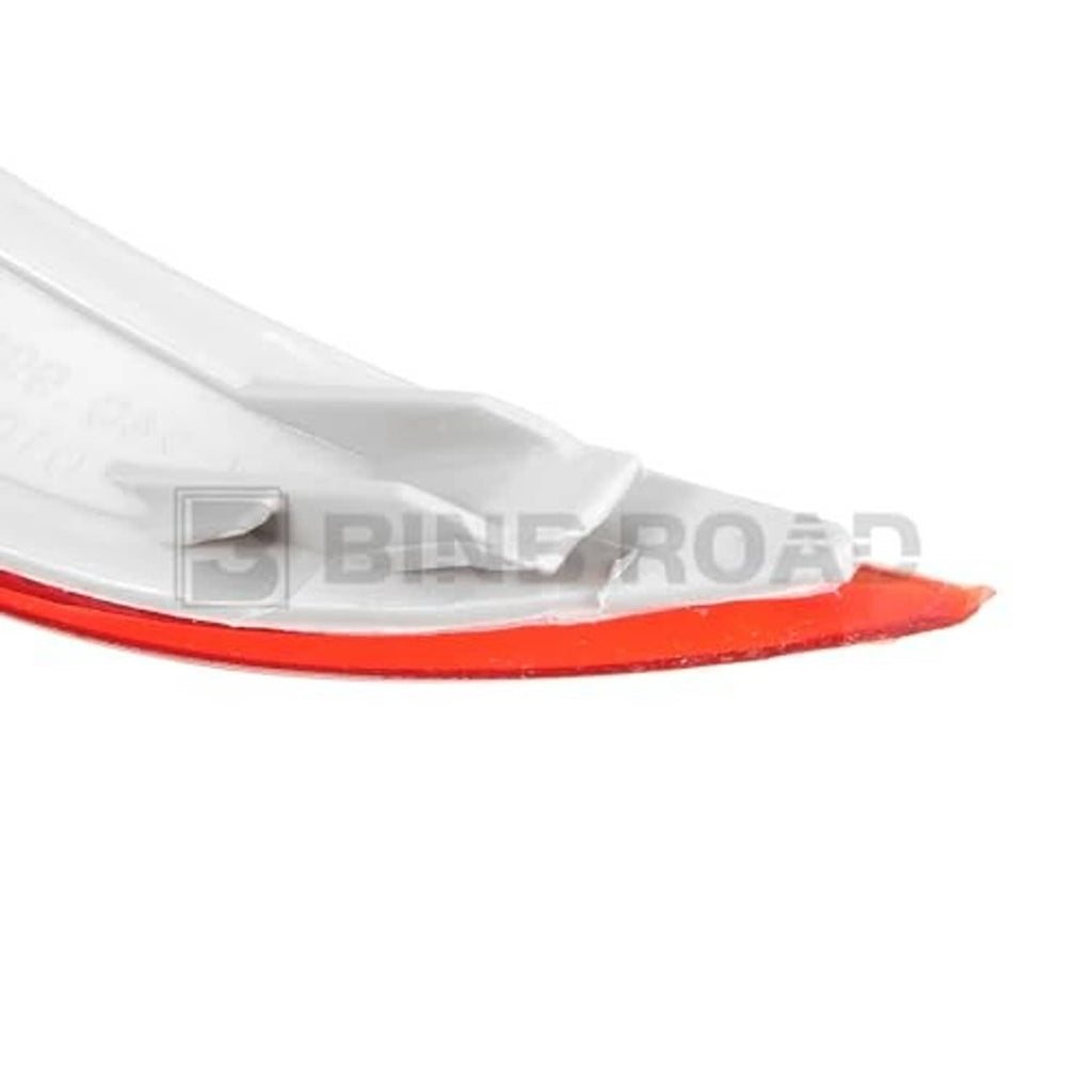 Close-up of red rear bumper reflector lens with curved edge and mounting lip.