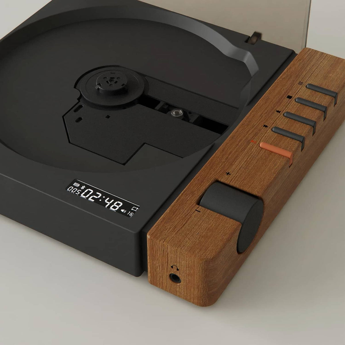 Portable CD player close-up of black disc tray and wood side with orange markings