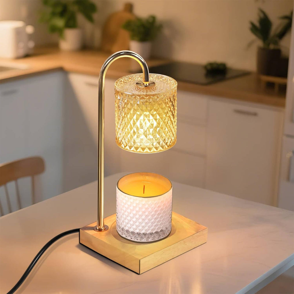 Table candle warmer lamp with gold stand, amber textured glass shade, lit candle on wooden base
