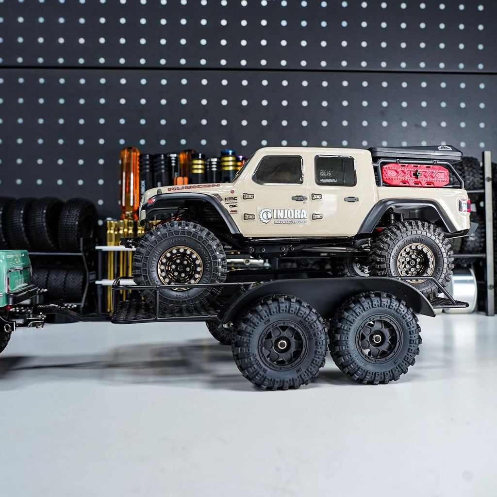 RC trailer with black mesh deck and large all-terrain tires on twin axles