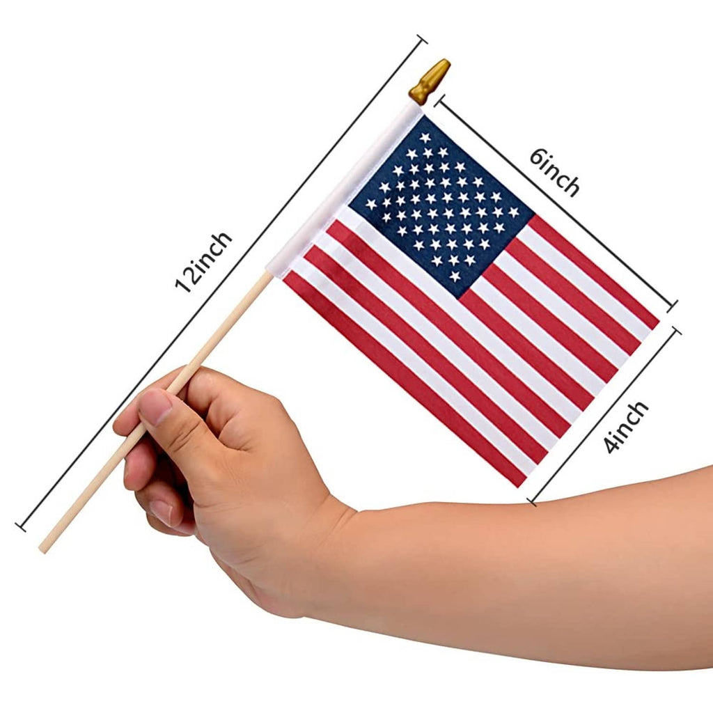 Small US flag on wooden stick held in hand, red stripes and blue star field