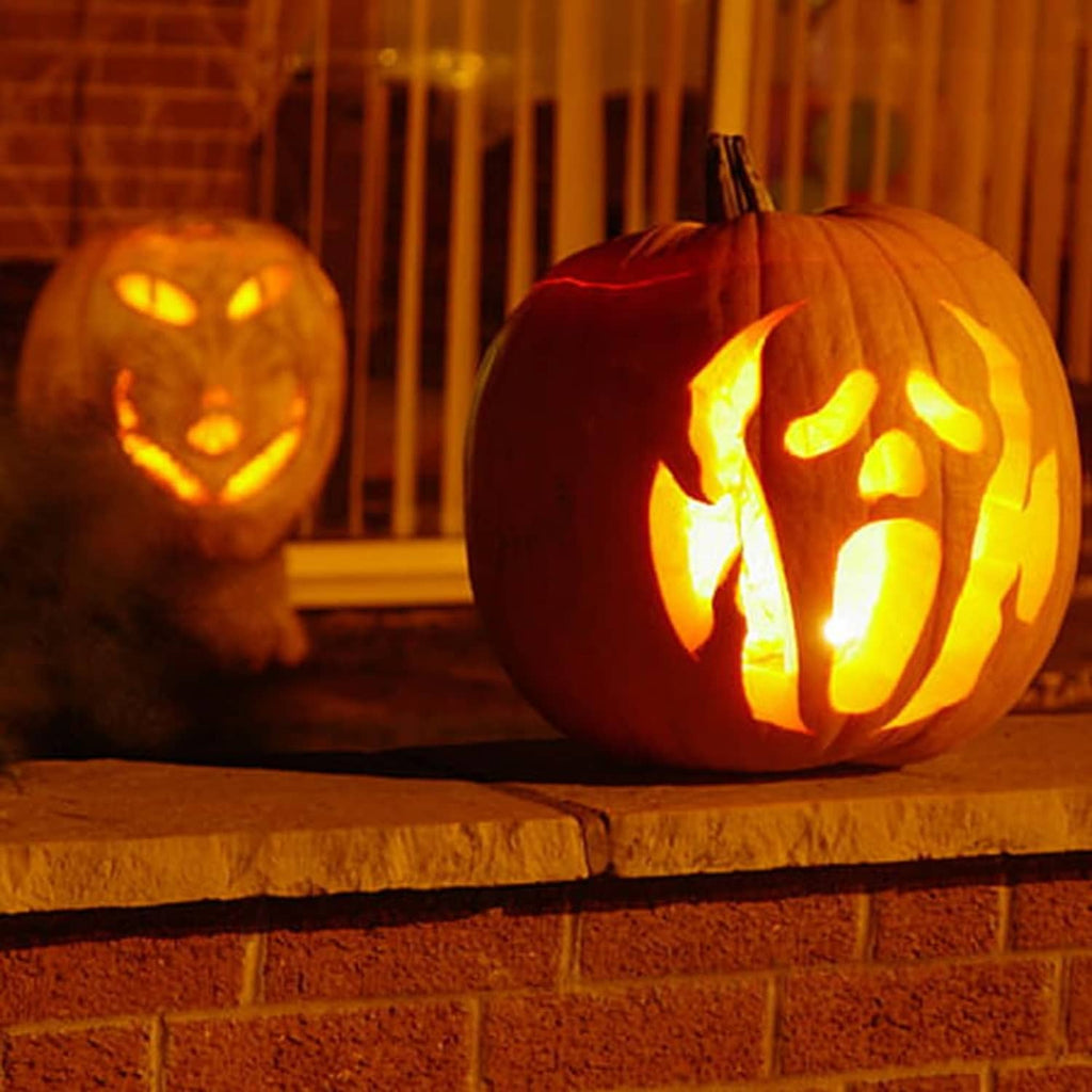 Warm glowing C7 LED bulbs used to light pumpkins on a patio.
