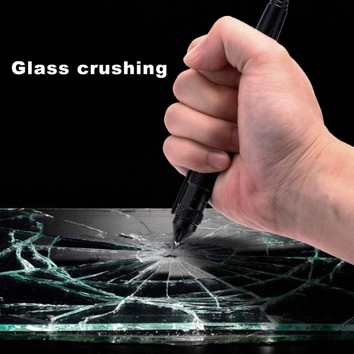 Hand using black tactical pen to crush shattered glass with the tip