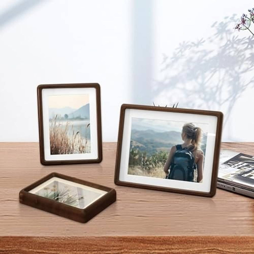Walnut wood photo frames on tabletop, including one A4 size frame