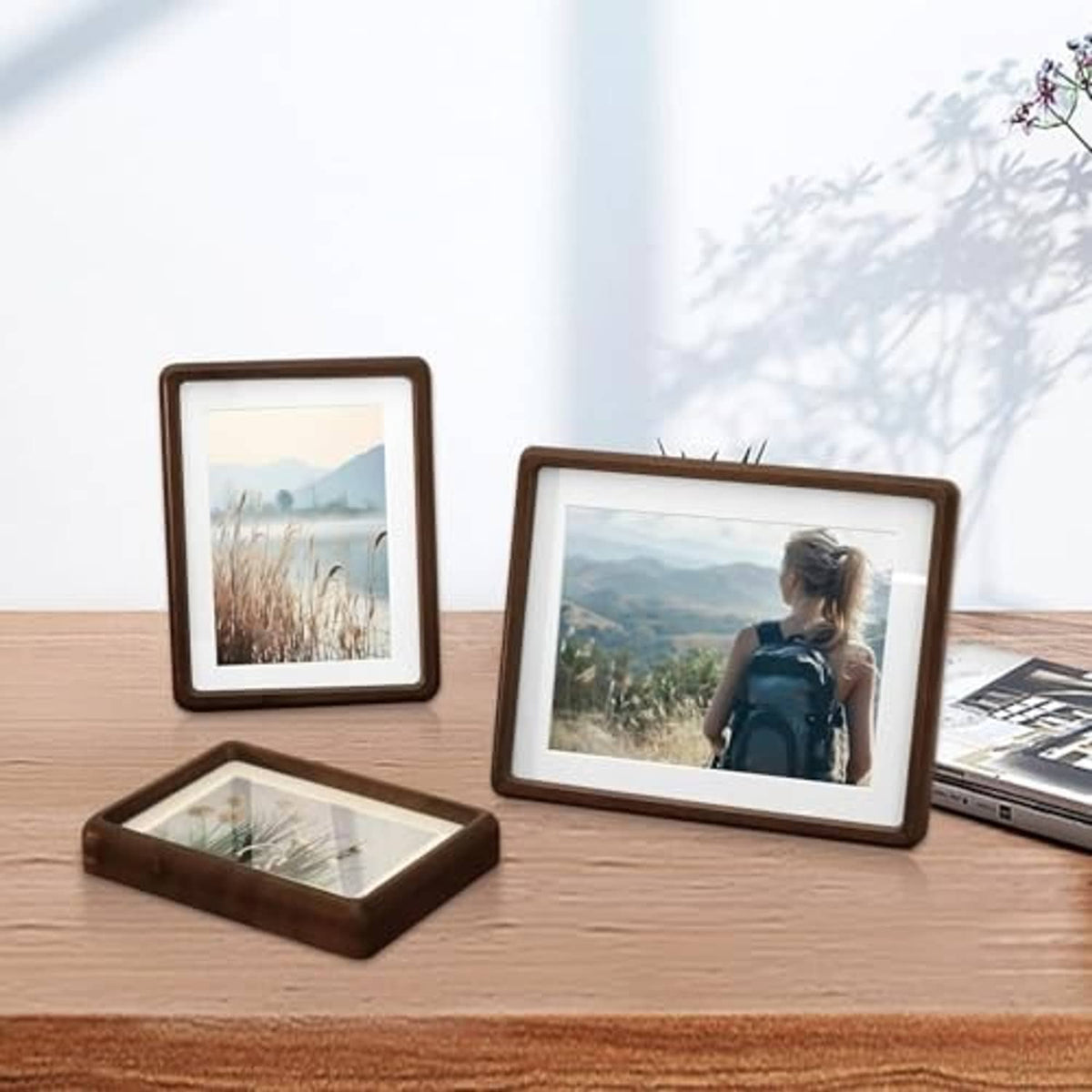 Walnut wood photo frames on tabletop, including one A4 size frame