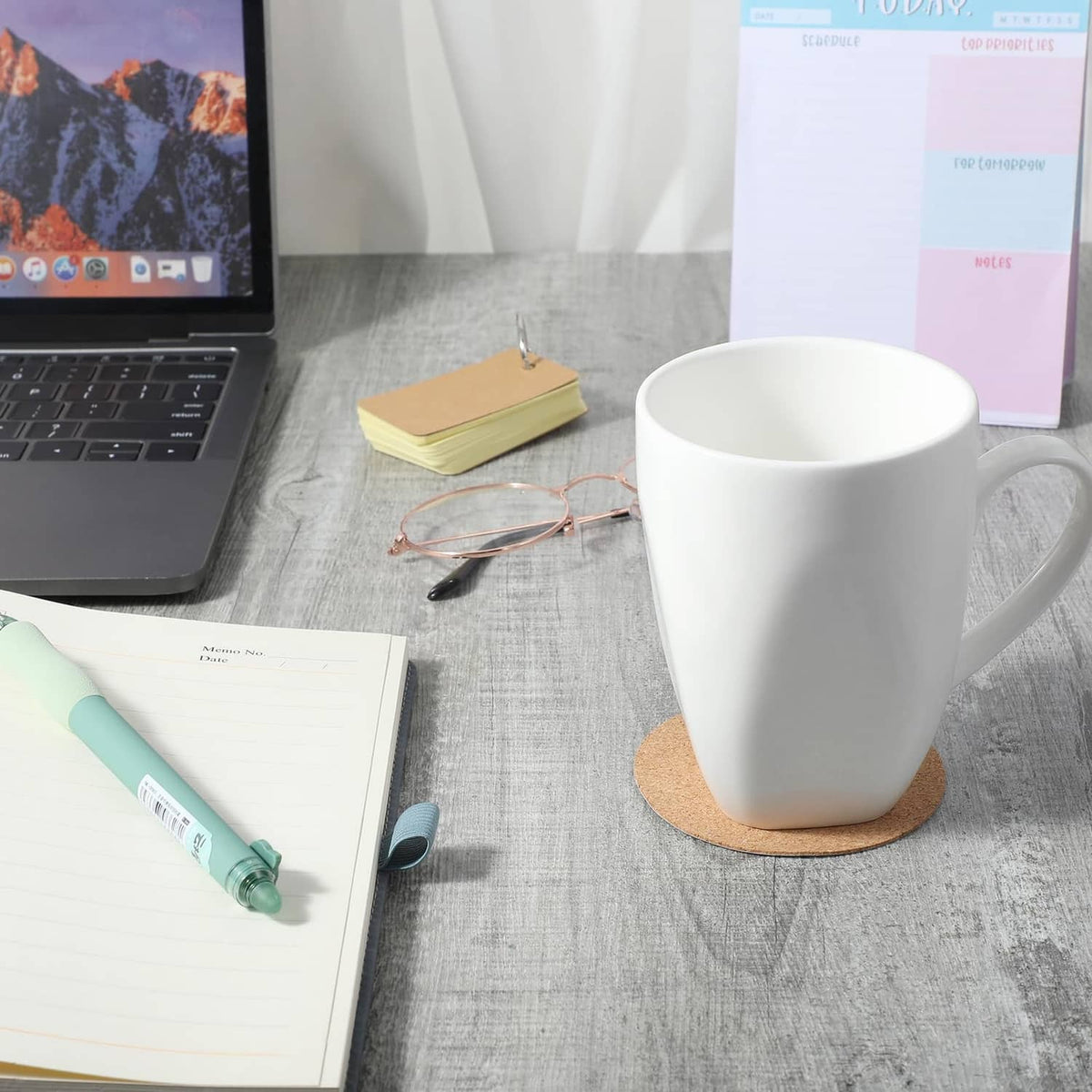 Cork coaster under a white mug on a desk