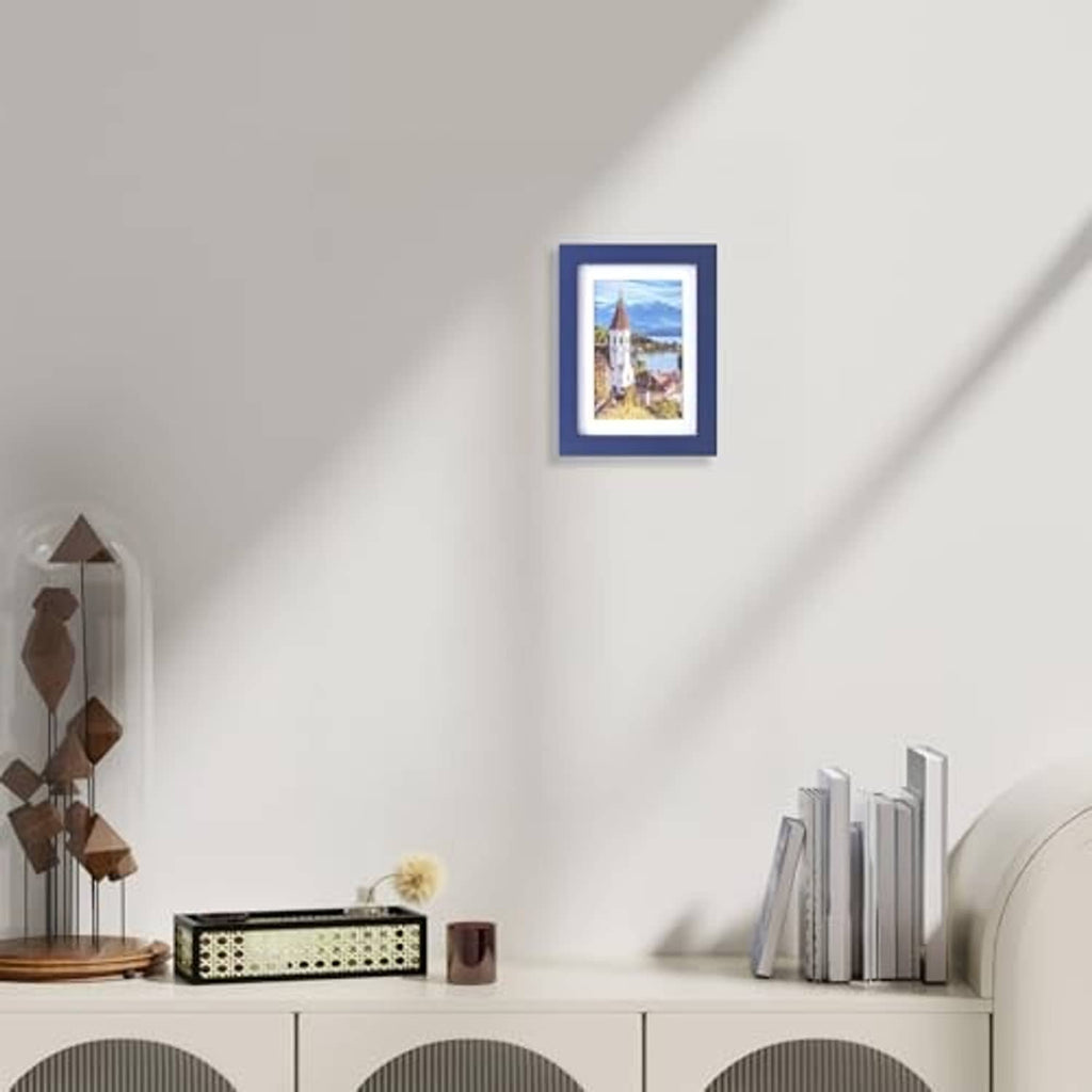 Dark blue photo frame on wall with small landscape picture inside