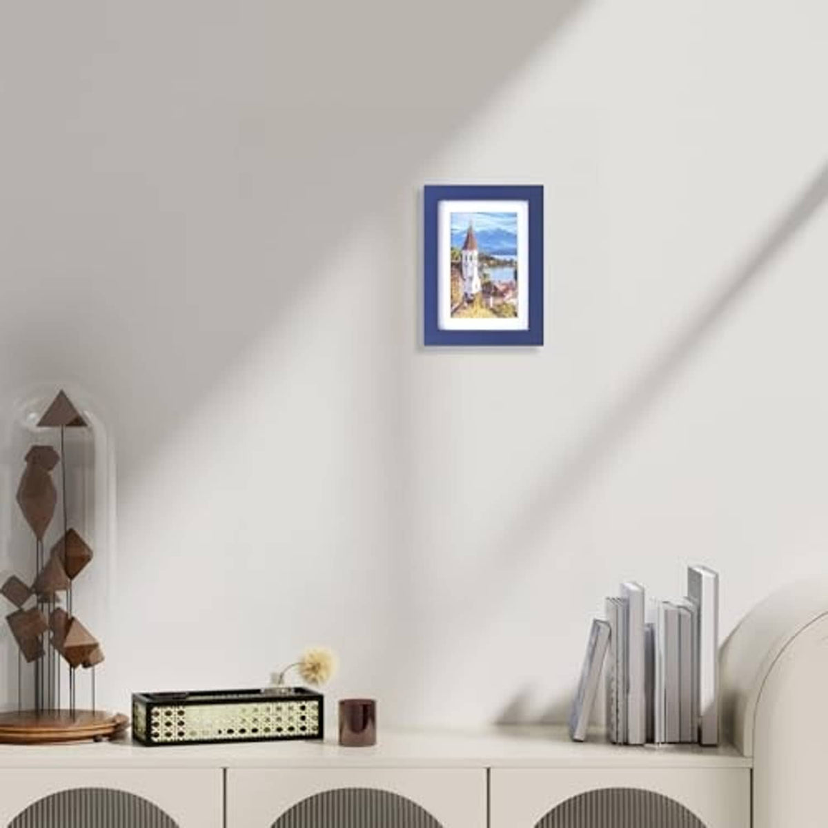 Dark blue photo frame on wall with small landscape picture inside