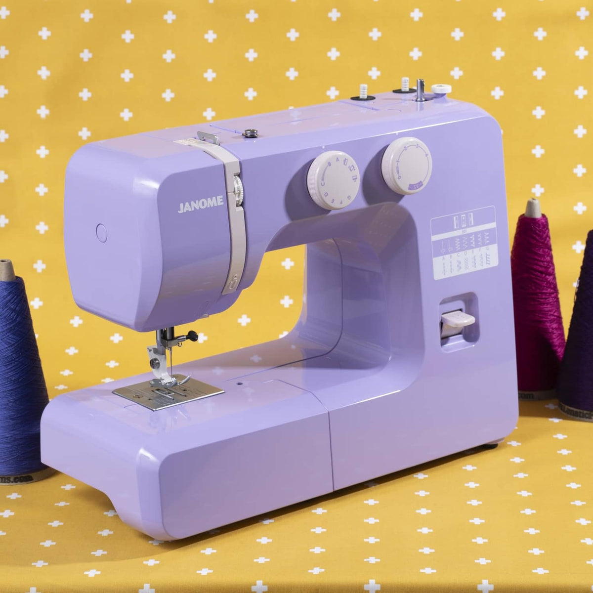 Janome purple sewing machine with control dials and front stitch area