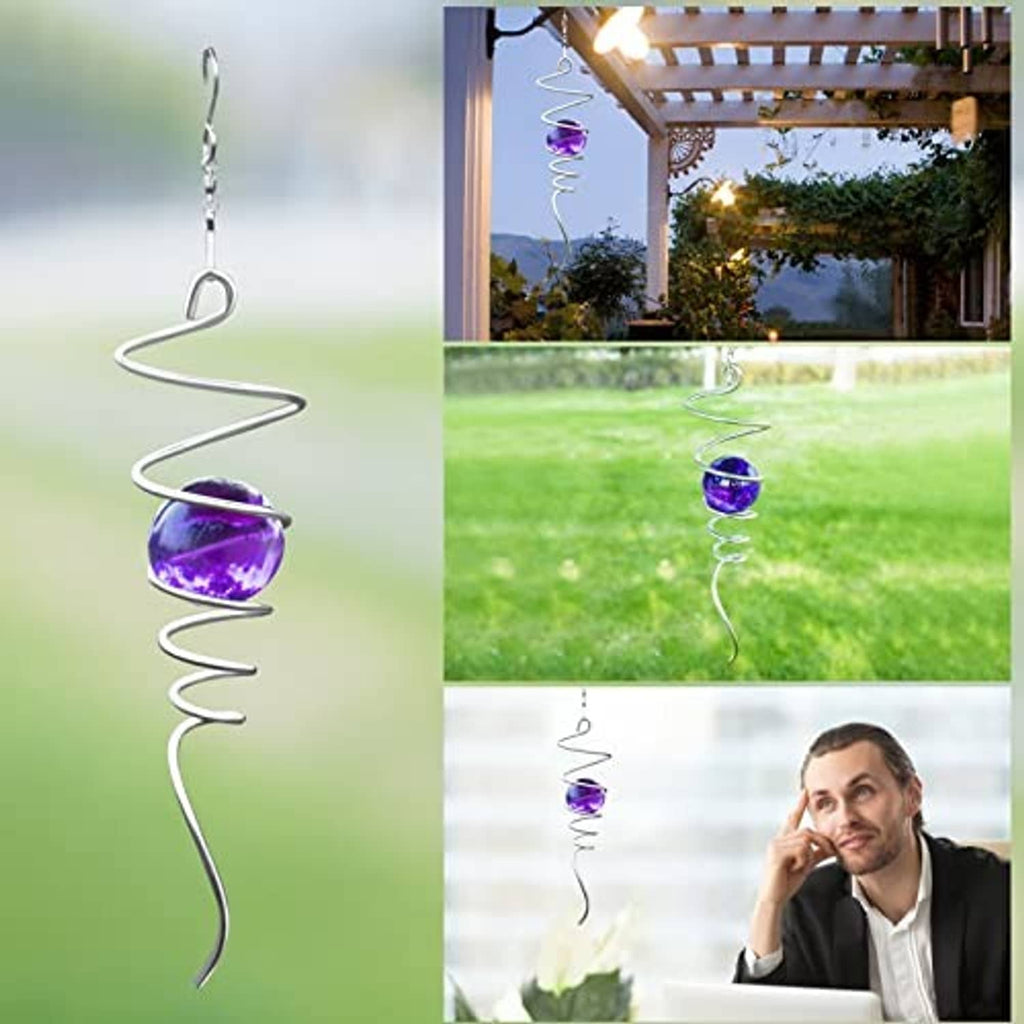 Purple gazing ball spiral tail wind spinner hanging from a garden pergola