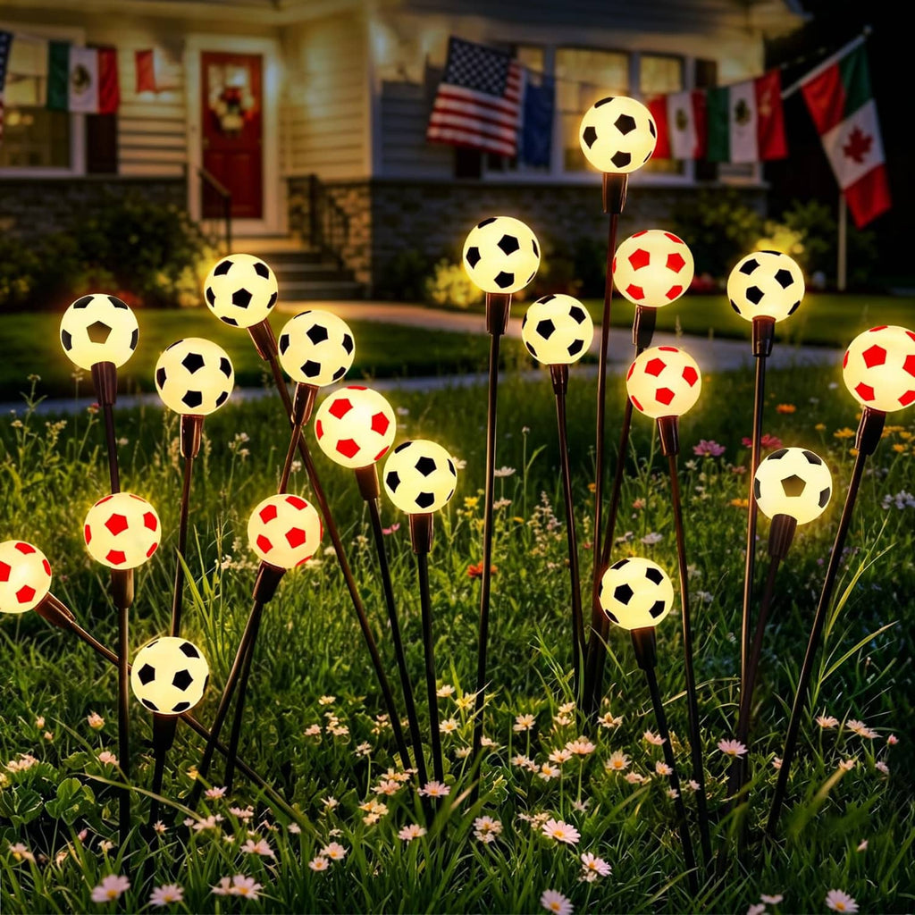Solar soccer light set with glowing soccer-ball bulbs on black stakes in outdoor grass