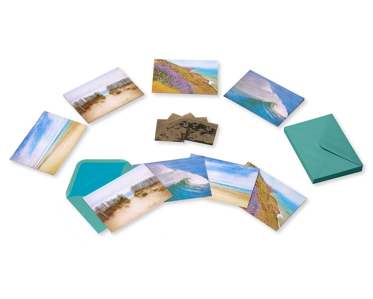 Seaside note cards with teal envelopes and beach artwork, cards spread out