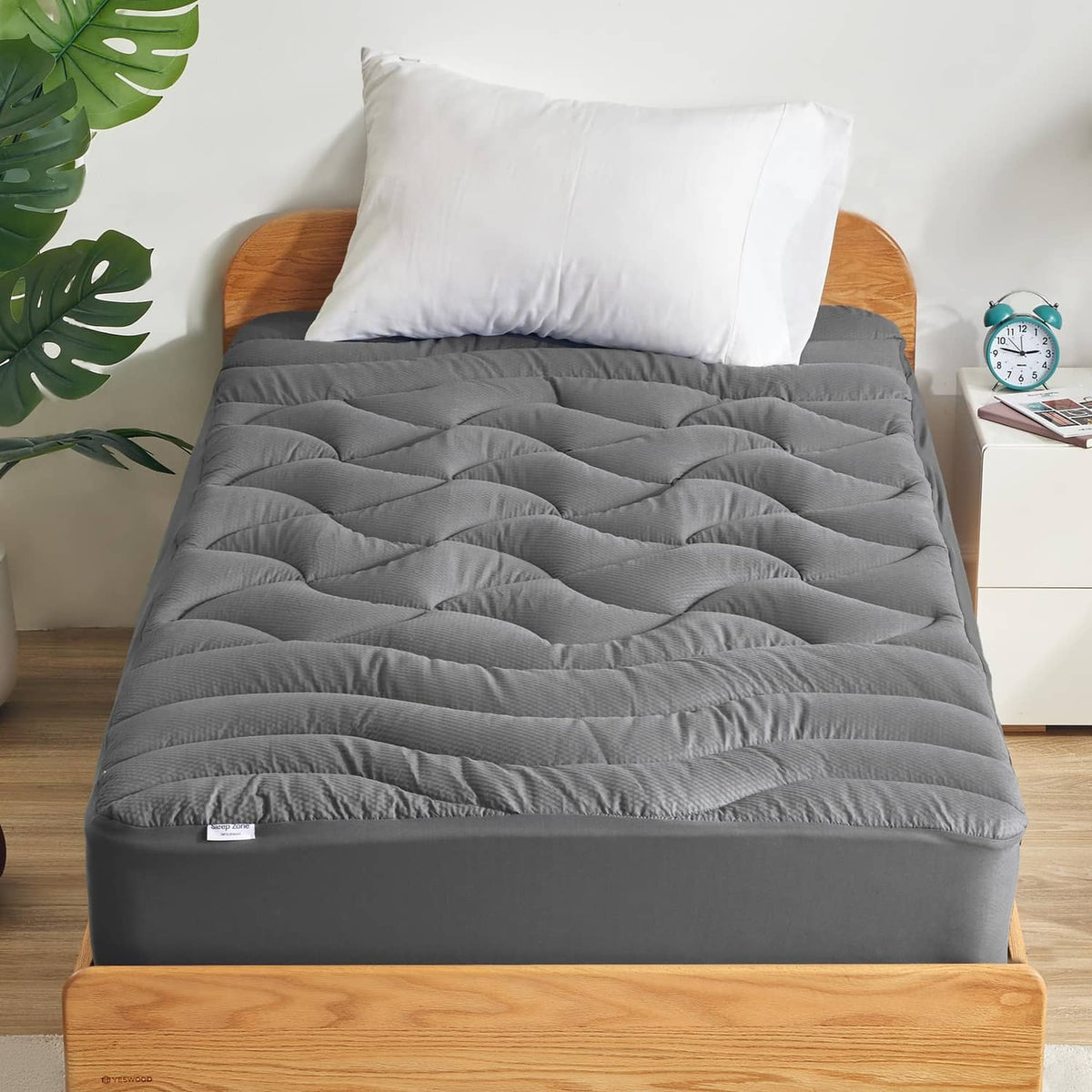 Gray quilted mattress topper with deep channel stitching and finished edges
