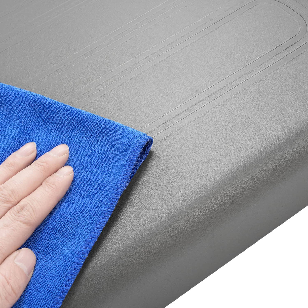 Gray cushion edge being wiped with a blue microfiber cloth