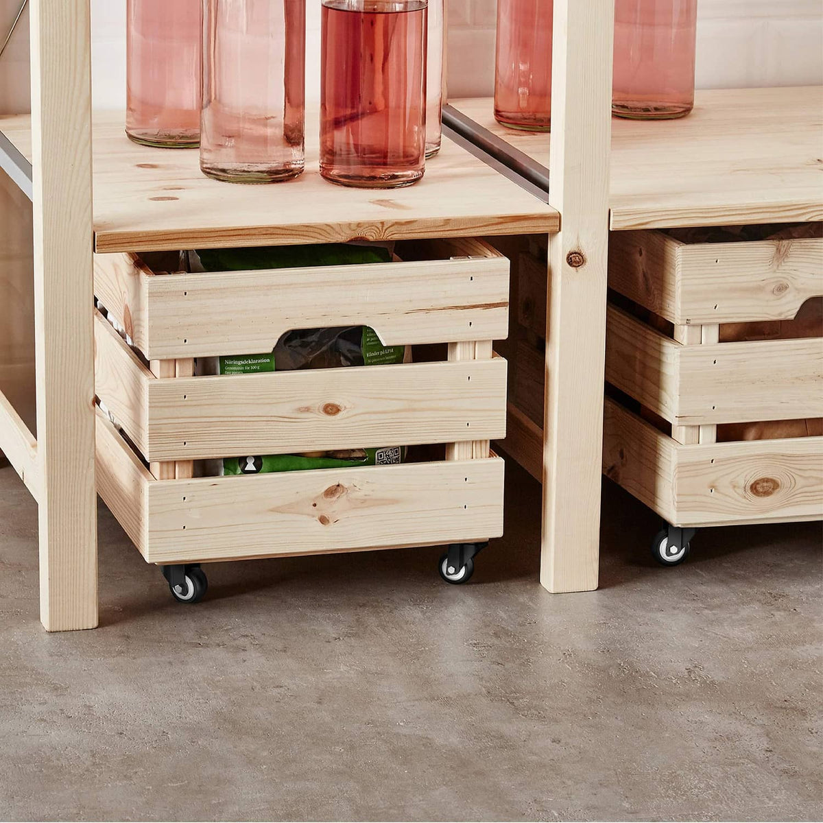 Black swivel caster wheels mounted on the underside of a wooden storage cabinet