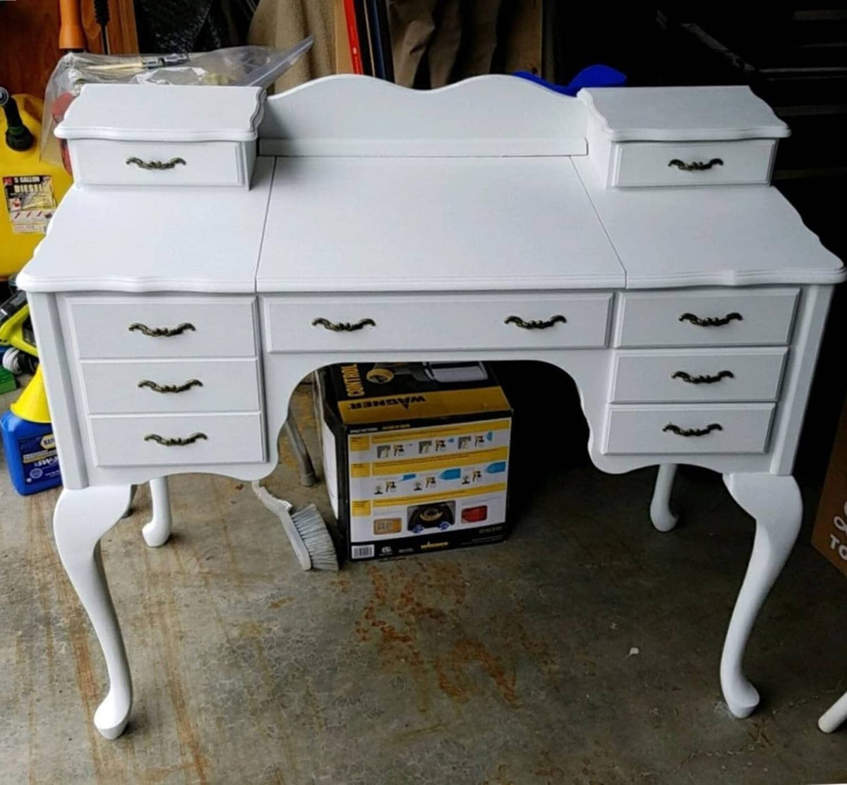 White cabinet with antique-style drawer pulls on small jewelry box compartments