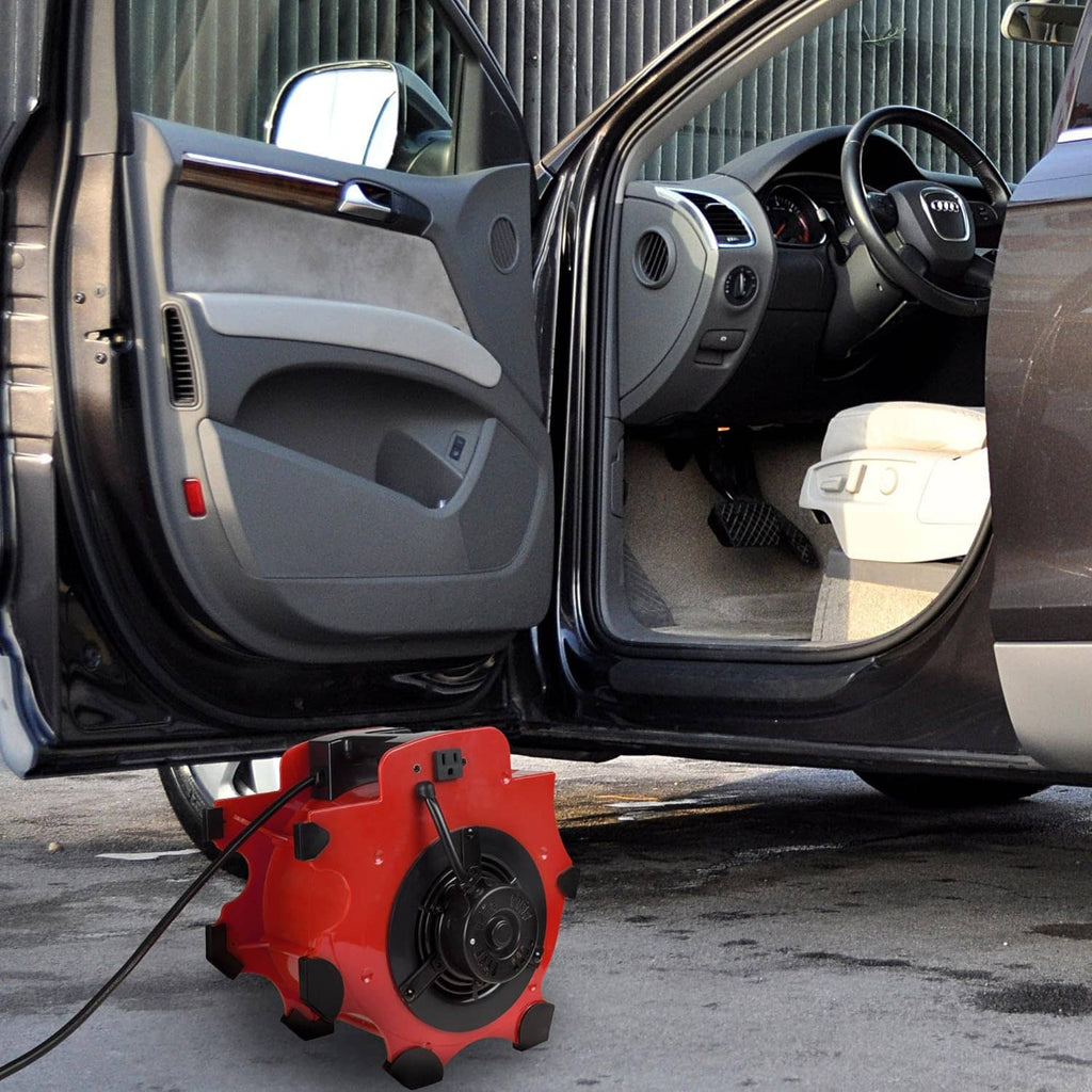 Orange blower fan dryer placed on ground near open vehicle door