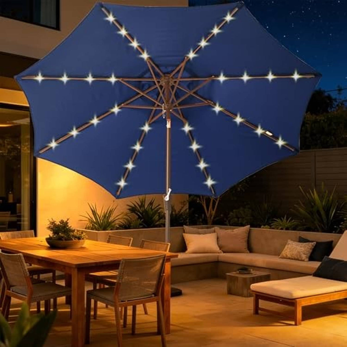 Navy solar LED patio umbrella open at night with warm starburst light strands