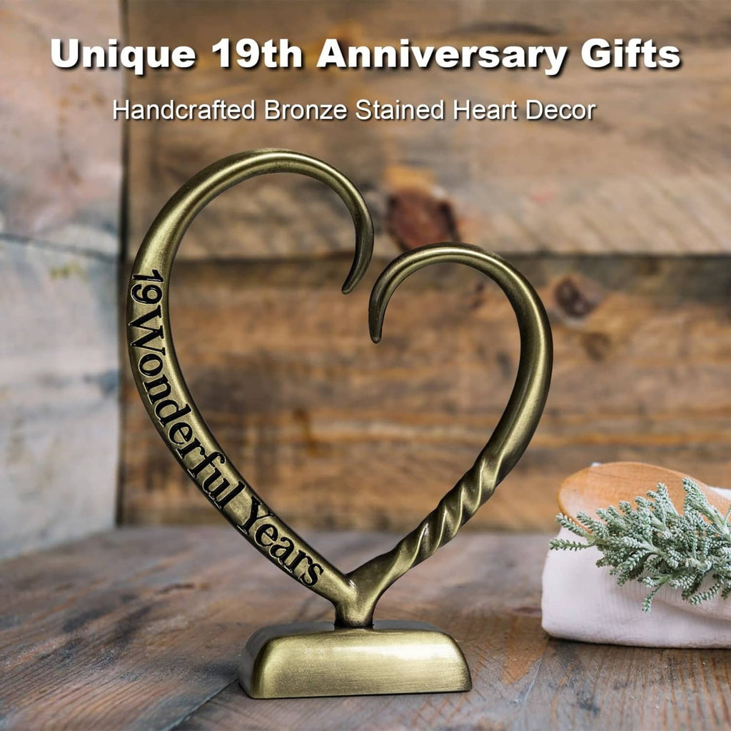 Bronze heart anniversary sculpture with twisted heart arms and engraved ribbon