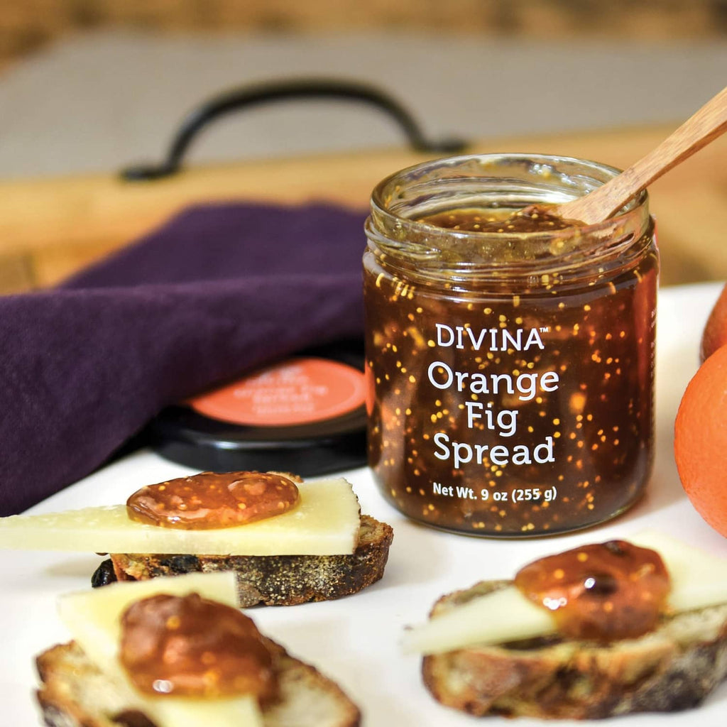 DIVINA Orange Fig Spread jar with toast slices and wooden spoon on a serving board