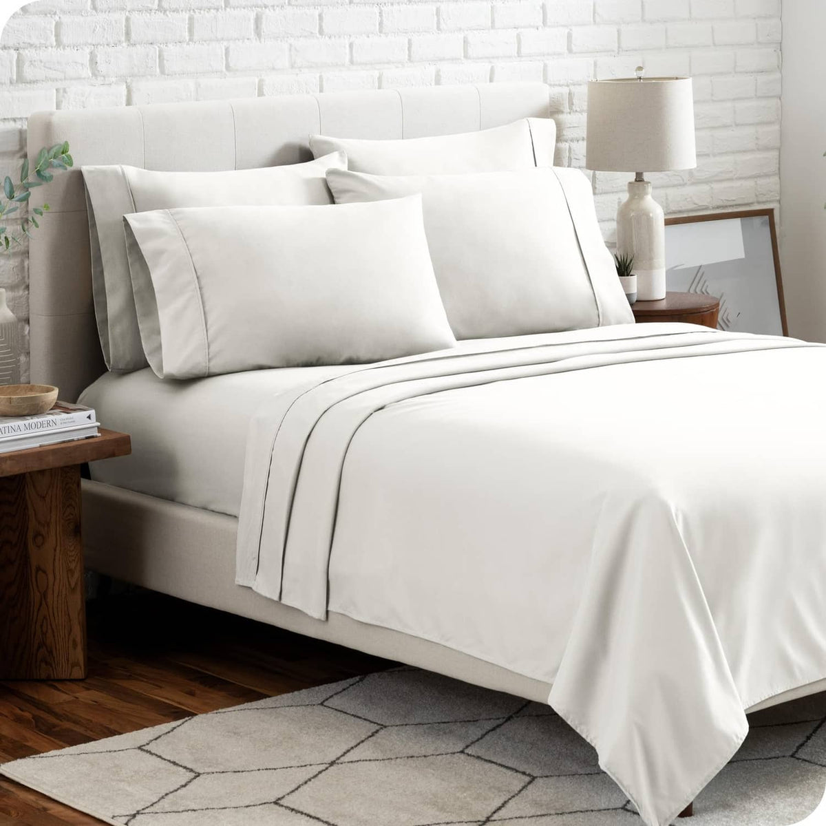 Cream microfiber bedding set on bed with pillows and neatly layered top sheet