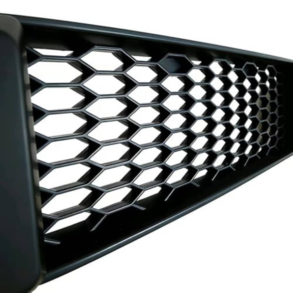 Close-up of black mesh grille with hexagonal honeycomb pattern and silver backing
