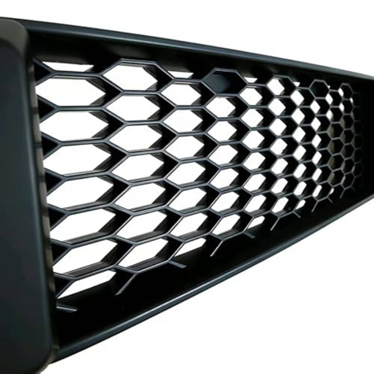 Close-up of black mesh grille with hexagonal honeycomb pattern and silver backing