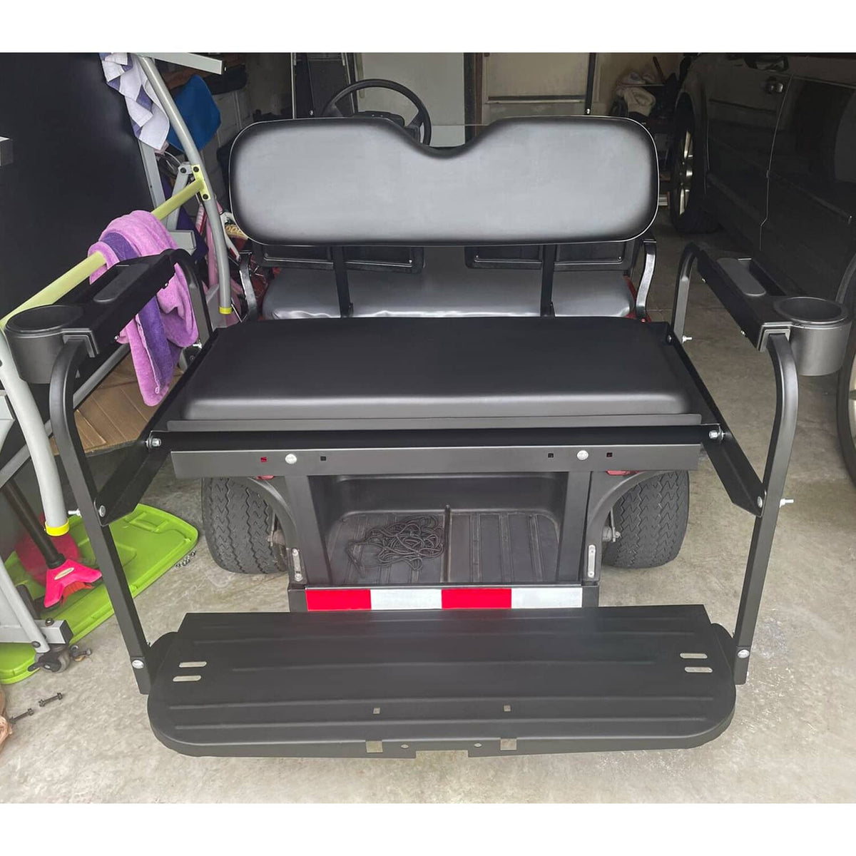 Black flip-folding rear back seat kit with cushioned seat and storage panel beneath