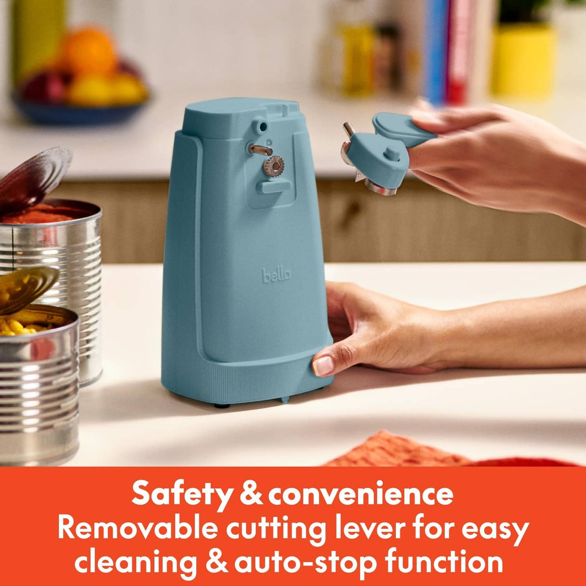 Teal electric can opener with removable cutting lever, hand pressing to open a can