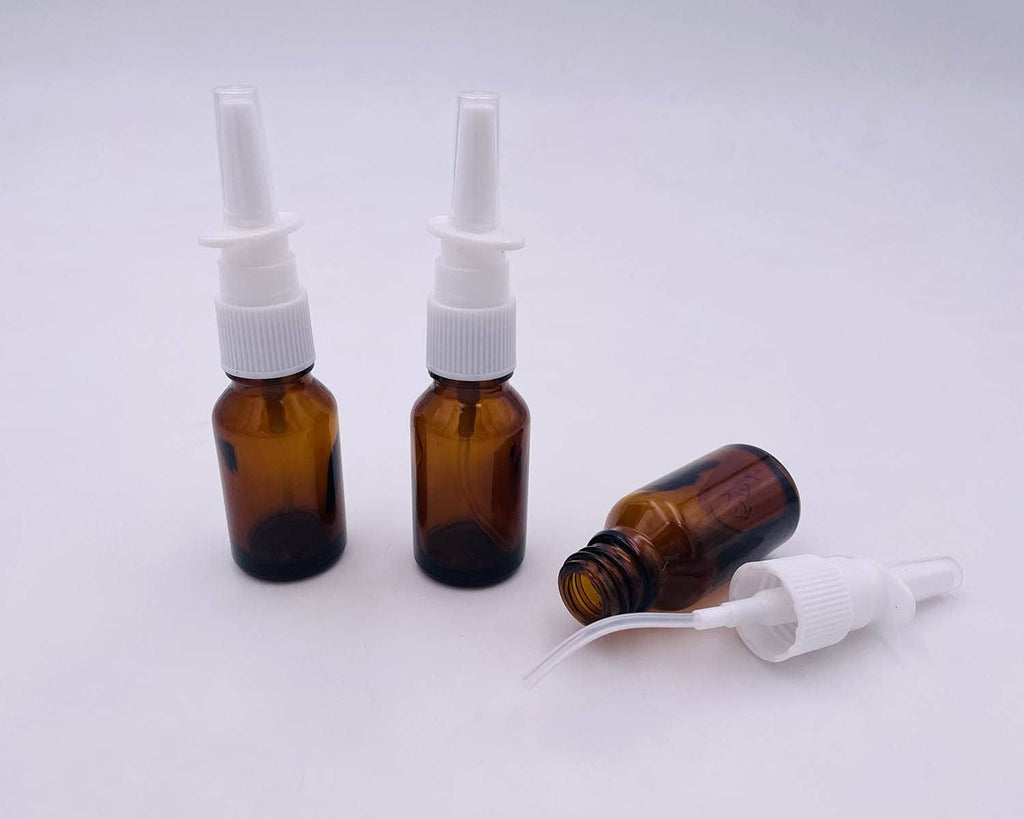 Amber glass nasal bottles with white pump applicators; one bottle shown with nozzle