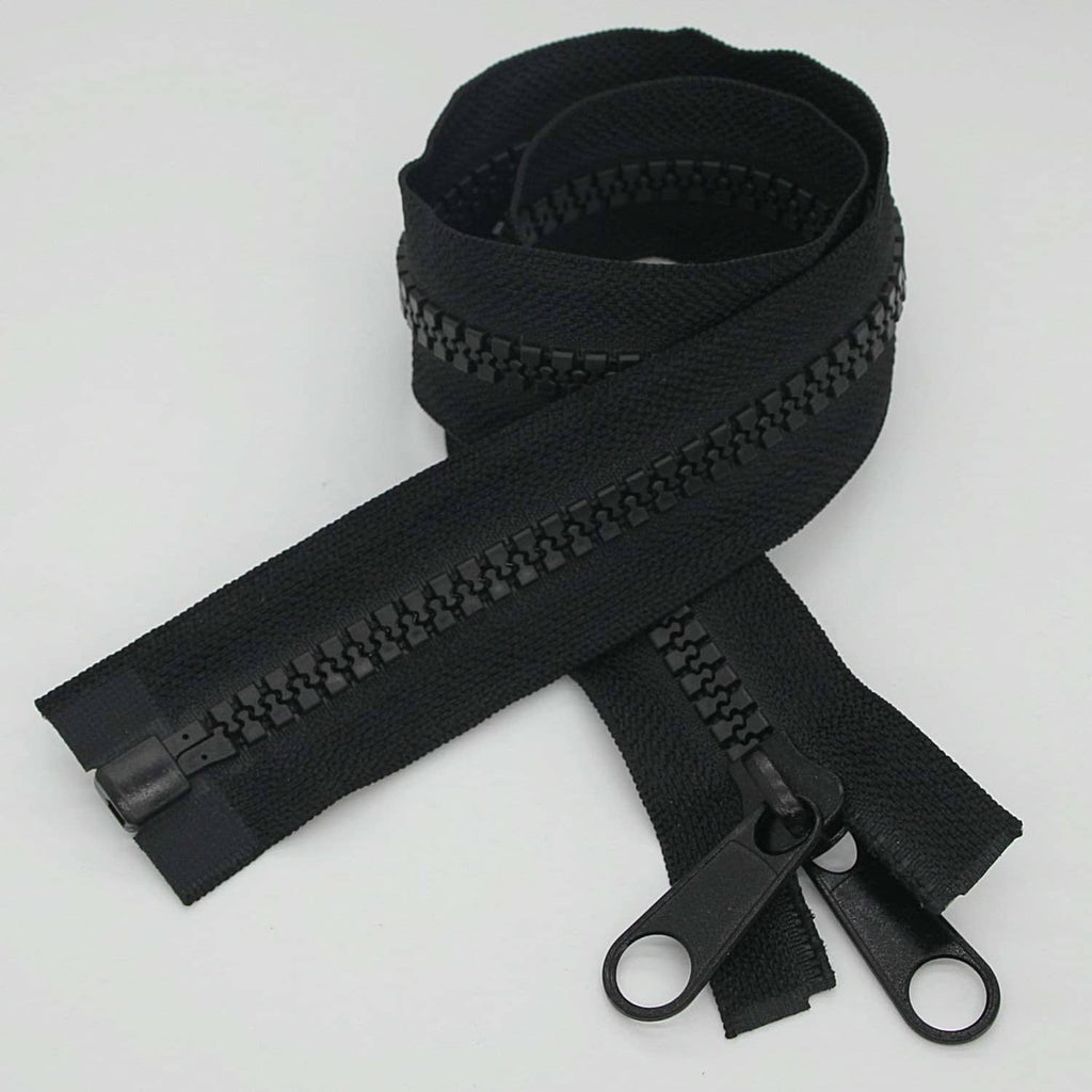 Black plastic separating zipper set with slider and two pull tabs, laid flat