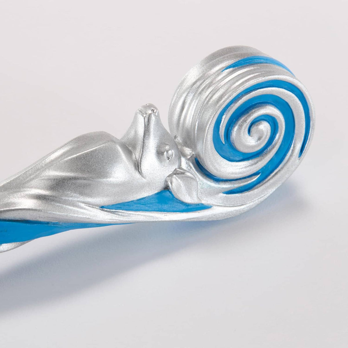 Close-up of silver wand tip with blue spiral swirl detail