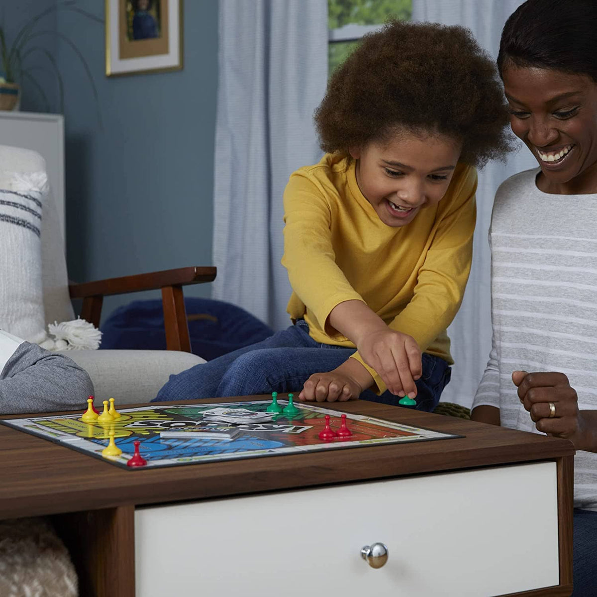Kids playing Sorry! board game on a coffee table with colorful pawns and markers